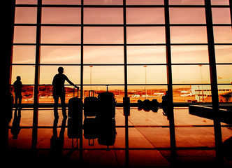 Silhouette of airline passengers in an airport lounge at the