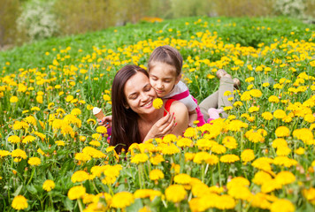 mum and kid girl child among yellow flowers dandelions