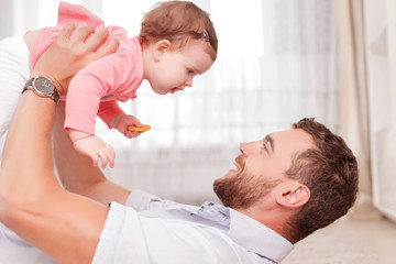 Fototapeta premium Vivacious father holding his kid in air 