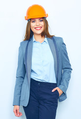 Smiling woman wearing a building helmet standing against white