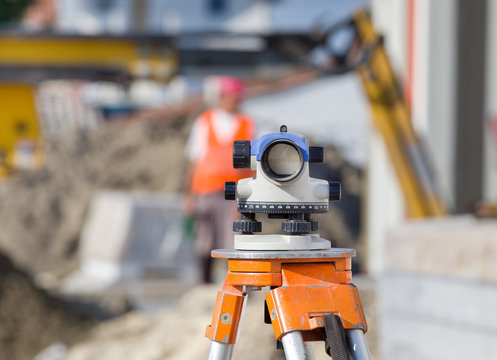 Theodolite and workers at construction site