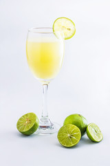 Glass of lime juice on white background