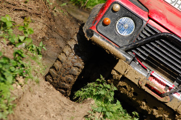 Landrover Defender off road at an angle on mud track on a 4x4 adventure trip © shoeboxdigital