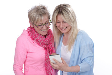 Junge und ältere Frau schauen auf das Smartphone