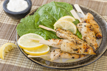 Chicken Satay - Char-grilled spicy mini chicken fillet skewers served with lemon and aioli dip.
