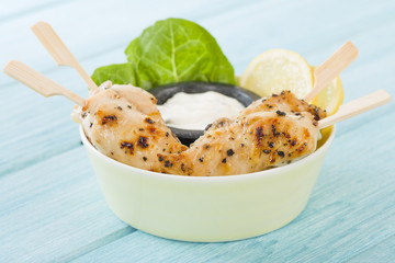 Chicken Satay - Char-grilled spicy mini chicken fillet skewers served with lemon and aioli dip.
