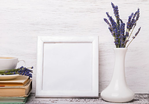 White colored interior, vase with lavender flowers and books 