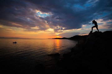 Man photographing landscape at sunset