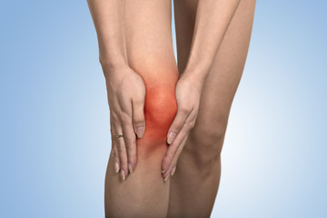 tendon knee joint problems on woman leg indicated with red spot