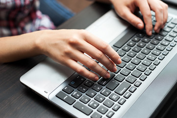 Hands on the laptop computer keyboard