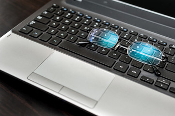 Close up pair of glasses on the laptop keyboard