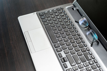 Close up pair of glasses on the laptop keyboard