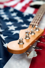 Obraz premium Vintage Bass guitar body on american flag background. selective focus image with shallow depth of field
