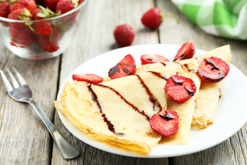 Tasty pancakes with strawberry on grey wooden background