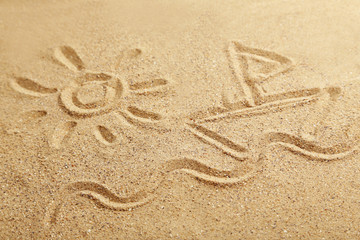 Drawing sun and ship on beach sand