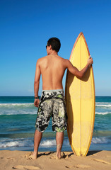 Naklejka na ściany i meble Surfer holding a surf board