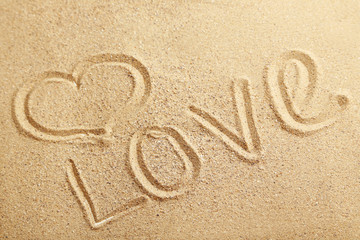 Love handwritten on a beach sand