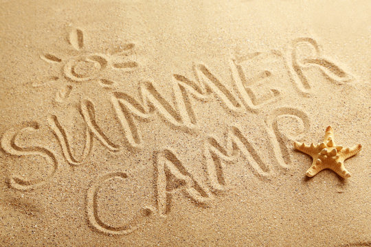 Summer camp handwritten in a beach sand