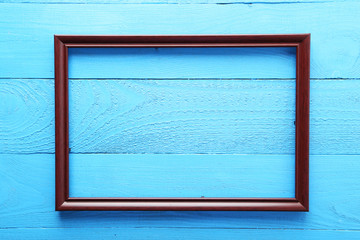 Wooden frame on blue wooden background