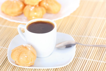 Cup of coffee and cakes on white plate