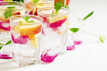 Fresh sparkling beverage with peaches and ice with rose petals o