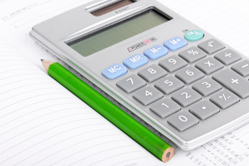 Calculator and pencil on notebook