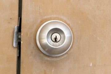 old and dirty Doorknob on brown wooden door