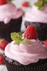 Chocolate cupcakes with pink cream and raspberry macro. Vertical 

