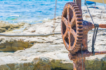 Rostiges Zahnrad vor Meereshintergrund