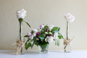 bodegón de dos rosas blancas y un centro de flores