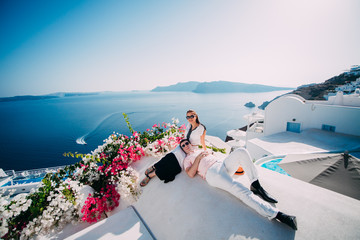 young couple embracing on the beach in Santorini, Greece.