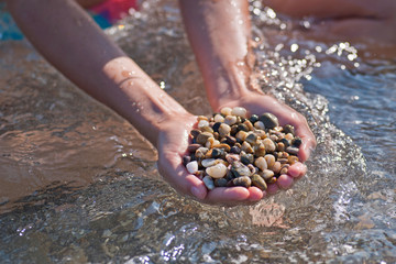 Handful of stones in hands, Against stones and sea
