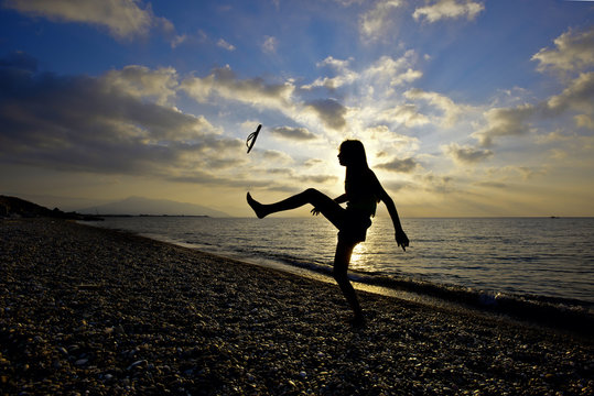 Young girl and sunset at the beach in Mediterranean sea