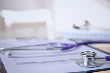 Purple stethoscope on the glass desk