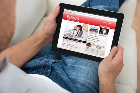 Person Watching News On Digital Tablet