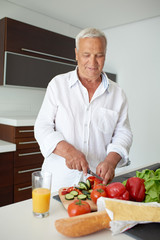 man cooking at home preparing salad in kitchen