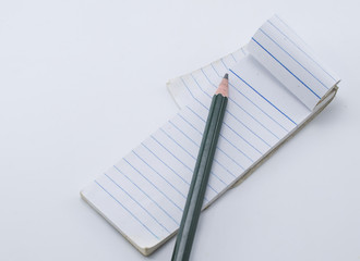 Pencil and note book on white board