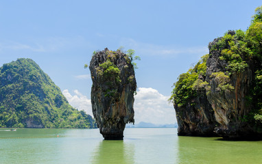 Fototapeta premium Rock hill and tree on green sea water