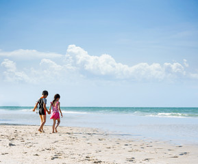 Brother sister holding hand walk on the beach