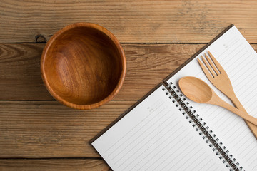 Notebook and wooden kitchenware in kitchen workplace