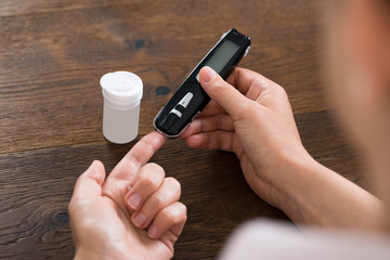 Fototapeta premium Person Hands Measuring Blood Sugar
