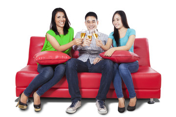 Obraz na płótnie Canvas Teenagers drinking champagne on sofa