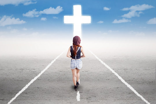 Teenage girl walking to the cross