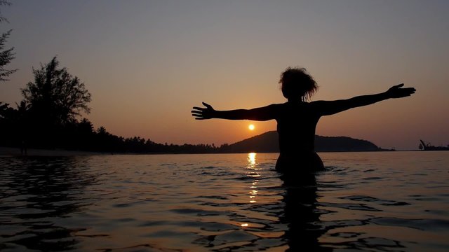 Free and Happy Woman in the Sea at Sunset. Slow Motion.