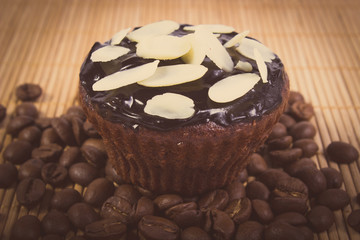 Vintage photo of chocolate muffins with sliced almonds and coffee grains