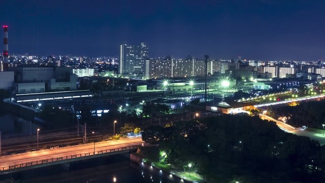 Time-lapse of traffic and trains crossing a bridge in Osaka at night