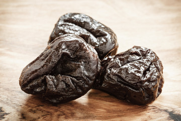 dried plums prunes on wooden table