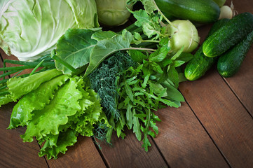 Useful green vegetables on a wooden background