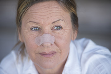 Confident woman with band aid on nose