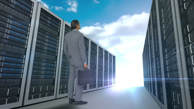 Businessman looking at server tower on cloudy sky background 